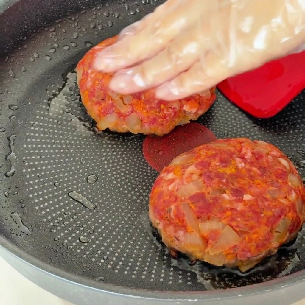 フライパンに蓋をして、ハンバーグを蒸し焼きにする様子。