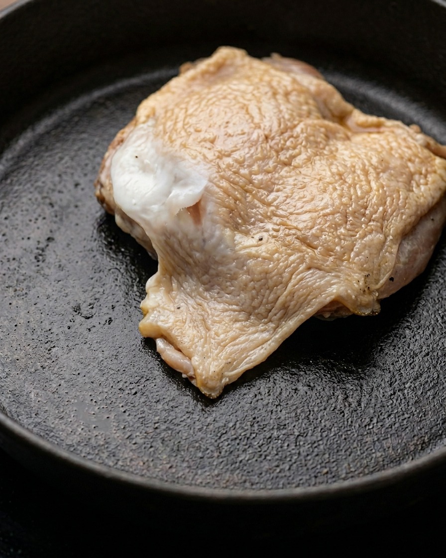 バターを溶かしたフライパンで鶏もも肉を焼いている様子