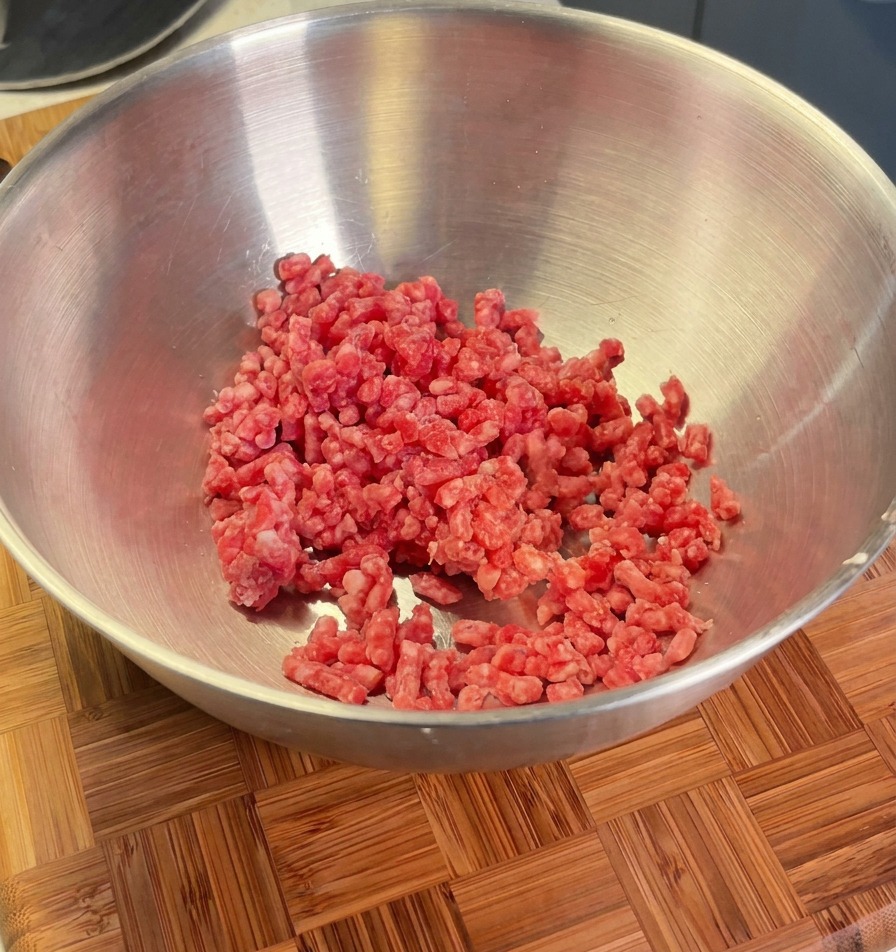 ボウルに入った牛ひき肉に、エシャロット、塩、黒胡椒を加える直前の様子