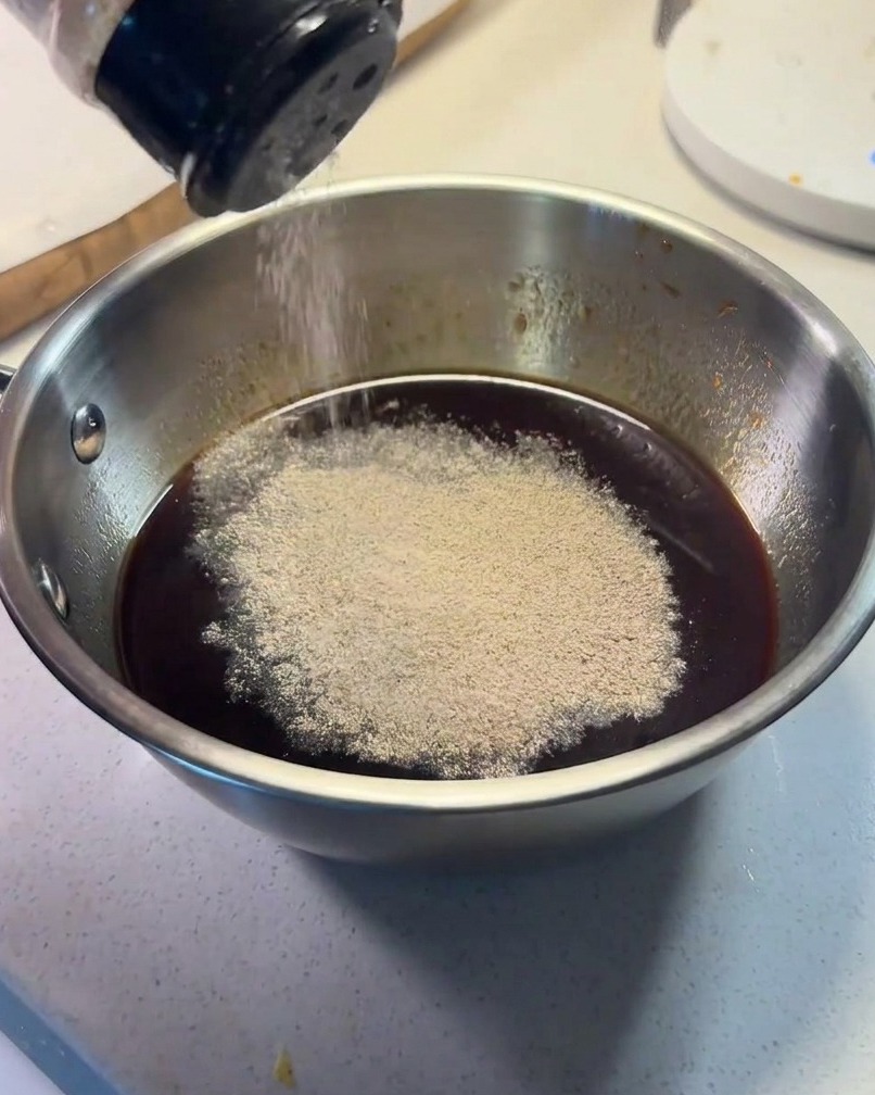 小さなボウルに調味料を合わせ、黒胡椒を振っている様子
