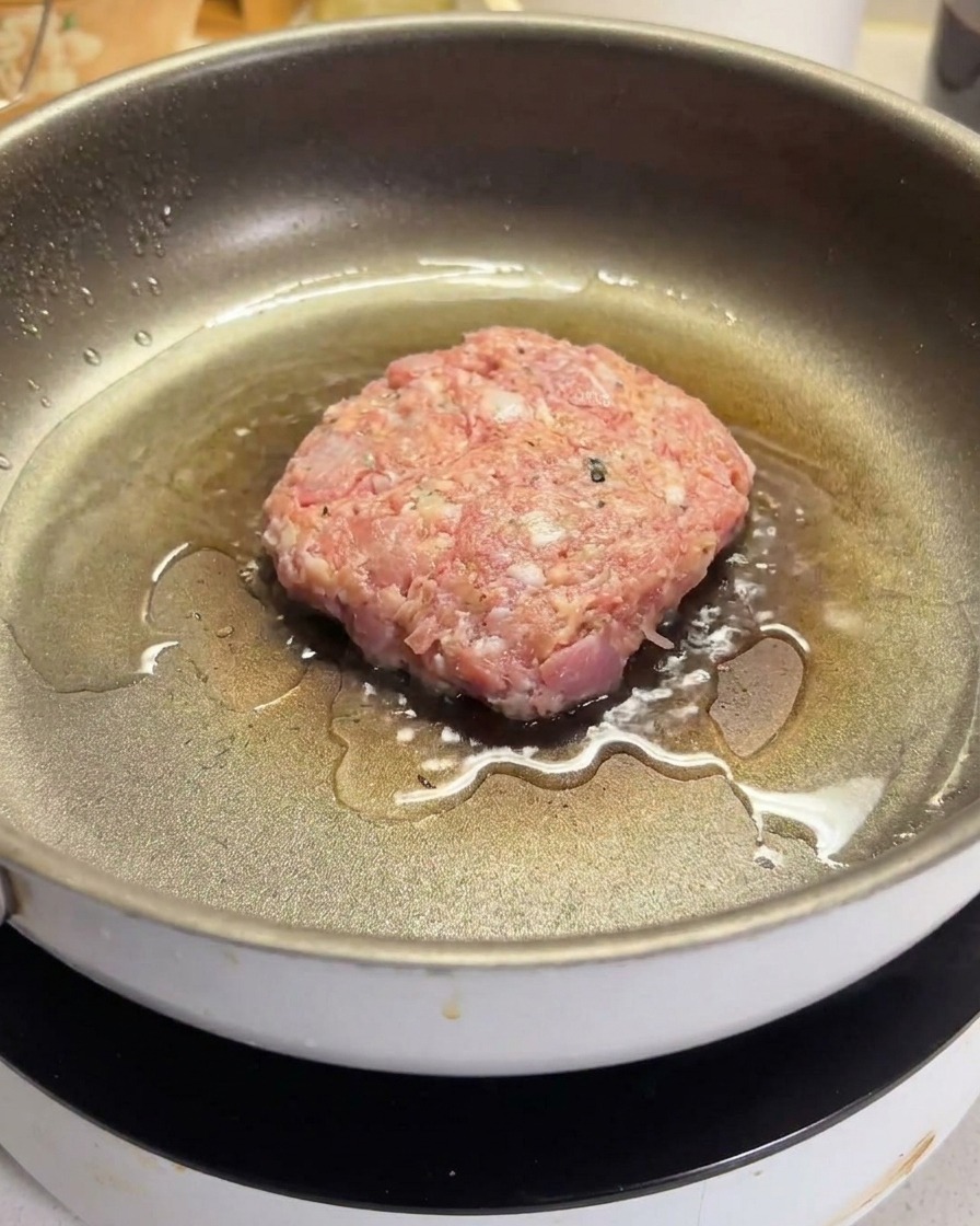 熱したフライパンでハンバーグを焼いている様子