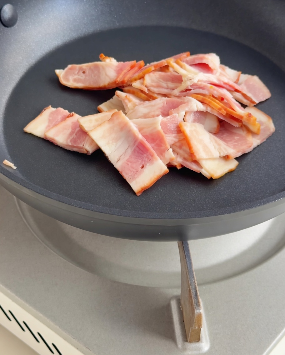 フライパンでキツネ色に炒められたカリカリのベーコン。