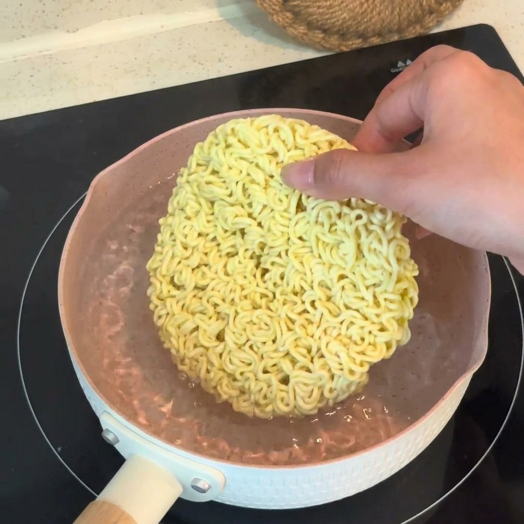 鍋に牛乳、生クリーム、アサリの出汁を注ぎ、じゃがいもとアサリを加えている様子。