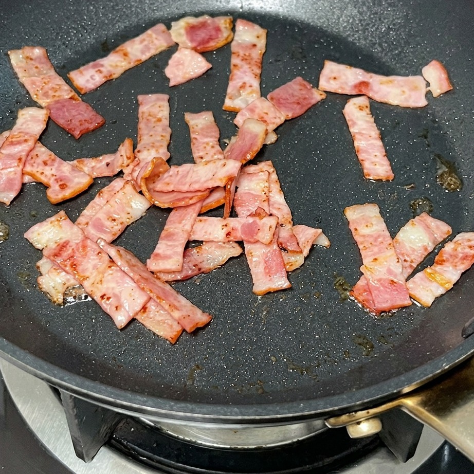 炒めたベーコンにバターが溶けている様子。