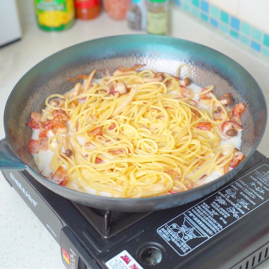 パスタに塩を振りかけて味を整えている様子