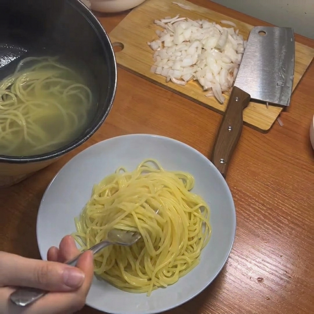 菜箸で茹で上がったパスタを引き上げる様子
