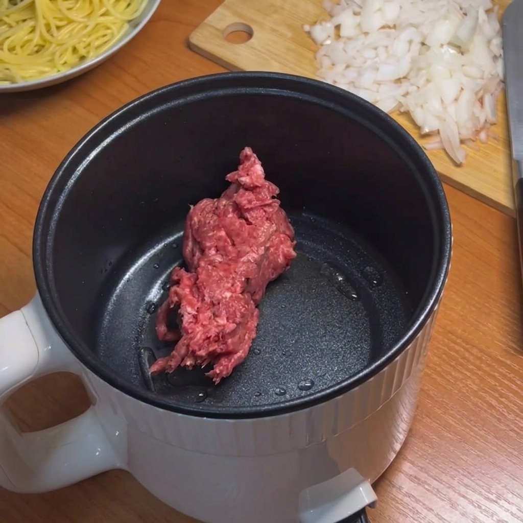 電気鍋でひき肉を炒める様子