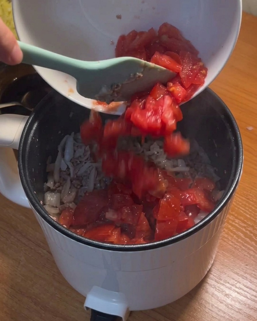 具材にカットトマトを加える様子