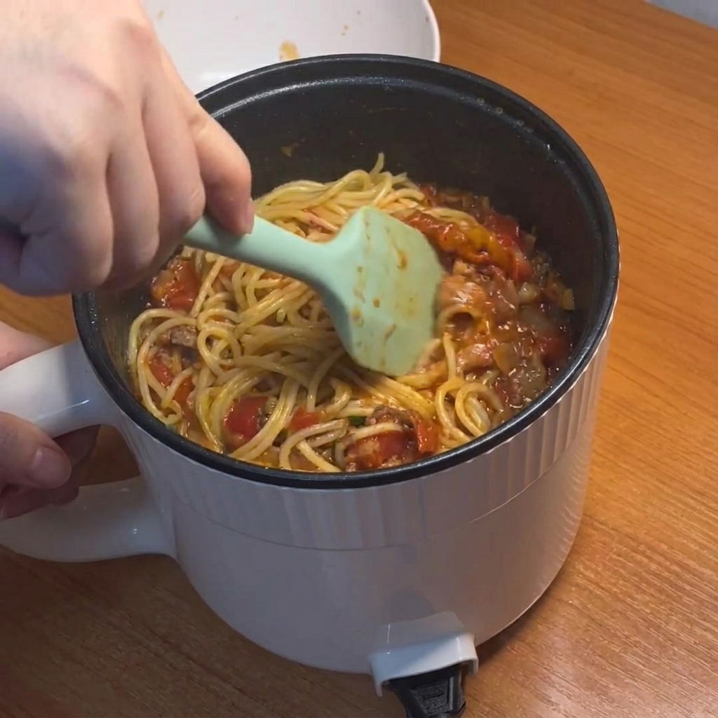 ソースとパスタを絡める様子
