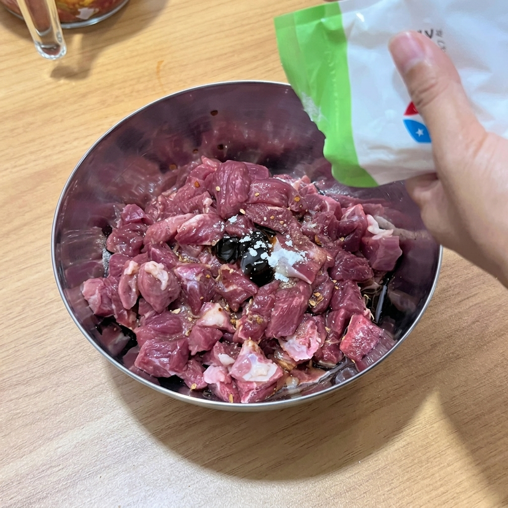 ボウルの中で牛肉と調味料をしっかり混ぜ合わせている様子。