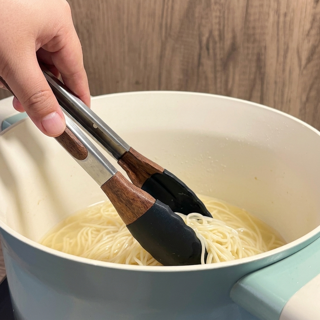 白い鍋で黄色い乾麺を茹でている様子。