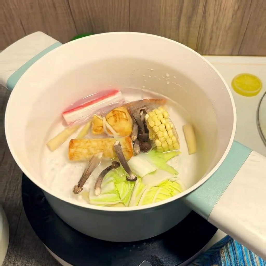 鍋の中でトウモロコシや海老を煮込んでいる様子。