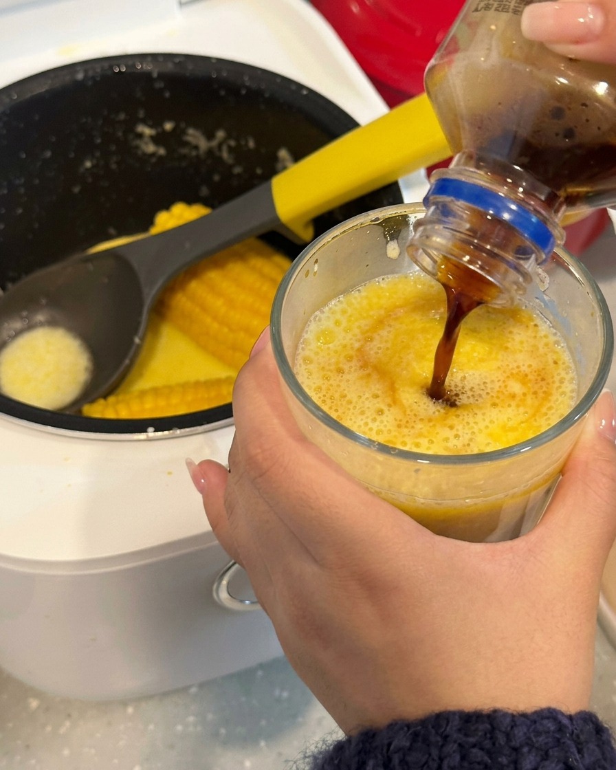 木製スティックでコーヒーとコーンスープを混ぜているアップの様子。
