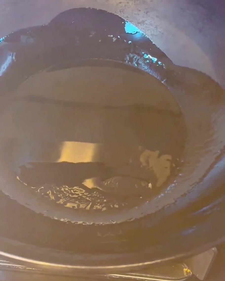中華鍋で豚バラ肉をきつね色になるまで炒めている様子。