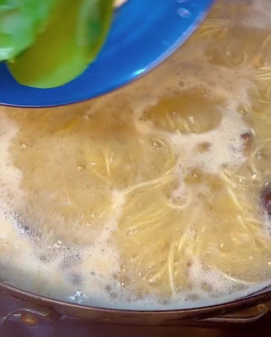 ラーメンの中に青梗菜を加え、仕上げている様子。