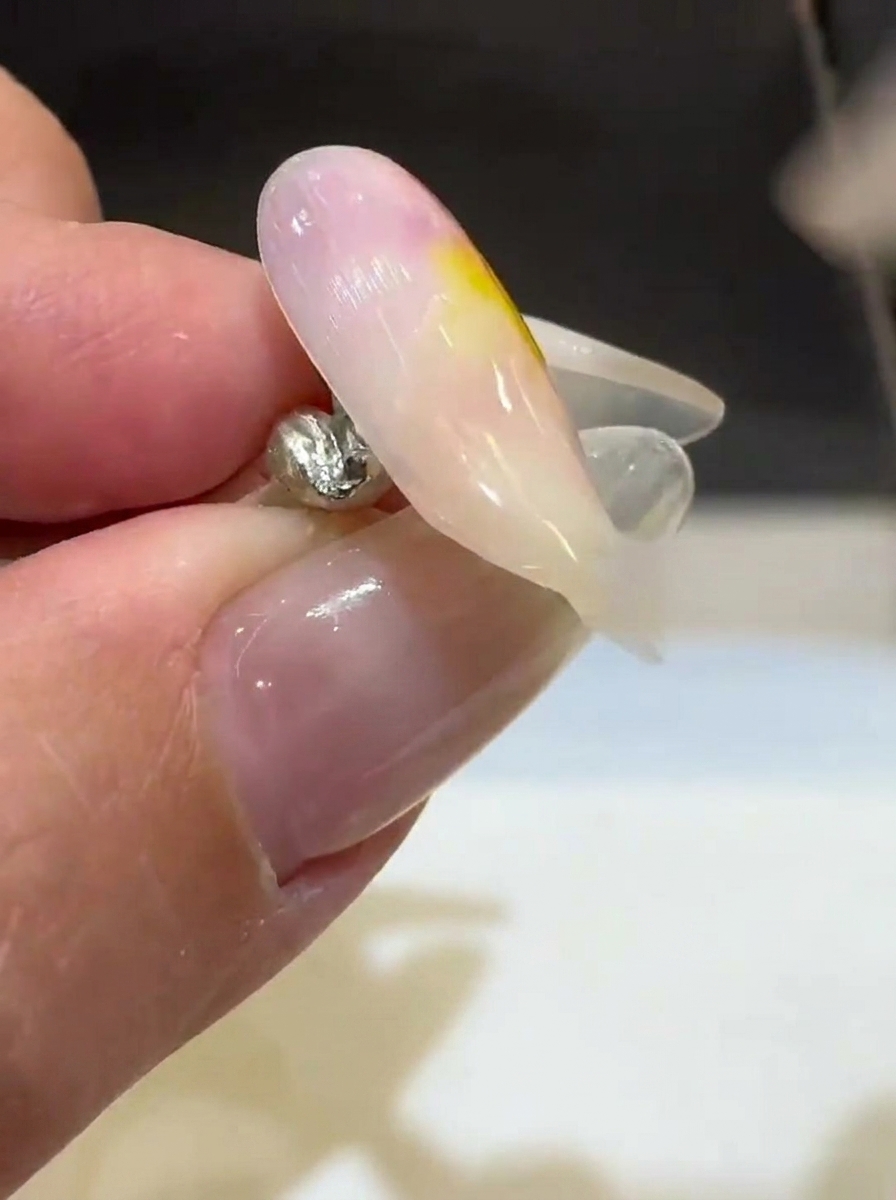 お箸でチンゲン菜をスープに沈める様子。