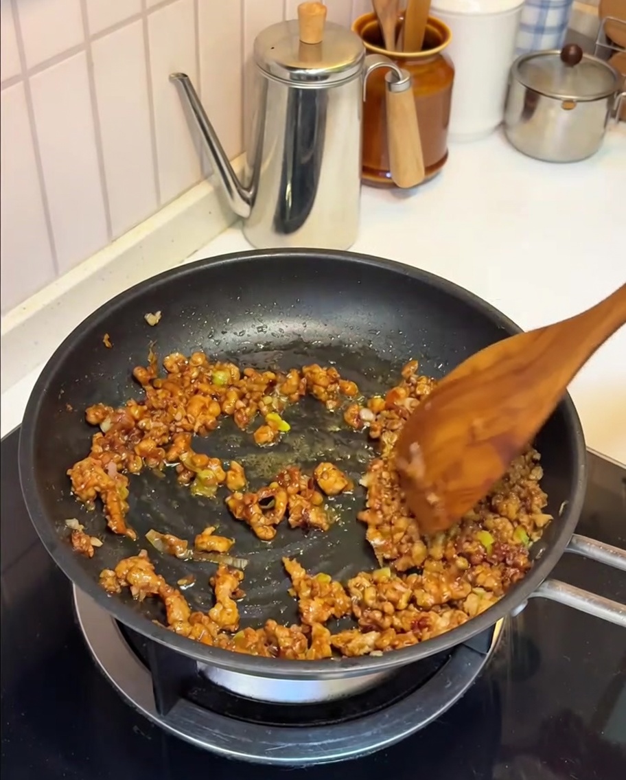 肉味噌に豆乳を注いでいる様子