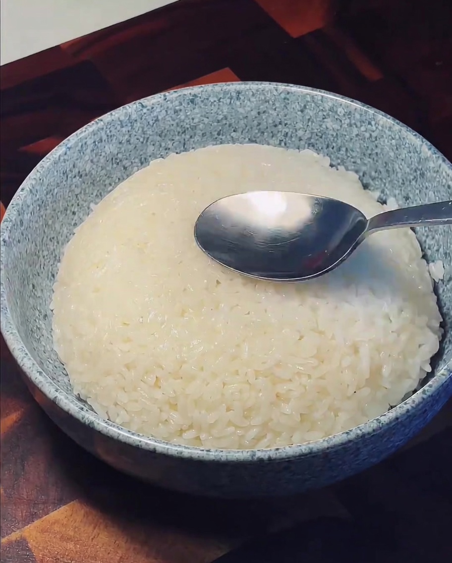 器に盛ったご飯の中央をスプーンでくぼませている様子。