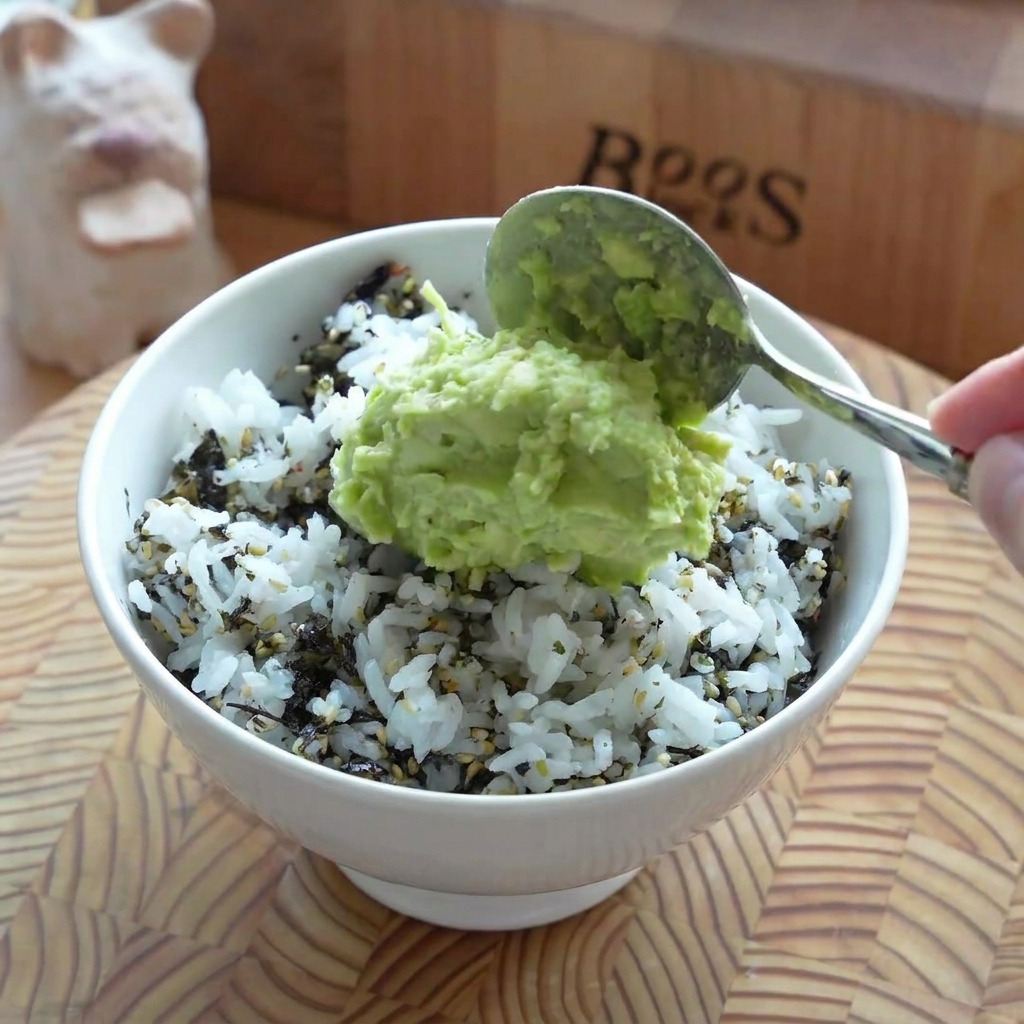 丼ぶりのご飯の上に、ペースト状のアボカドがなめらかに広げられている様子。