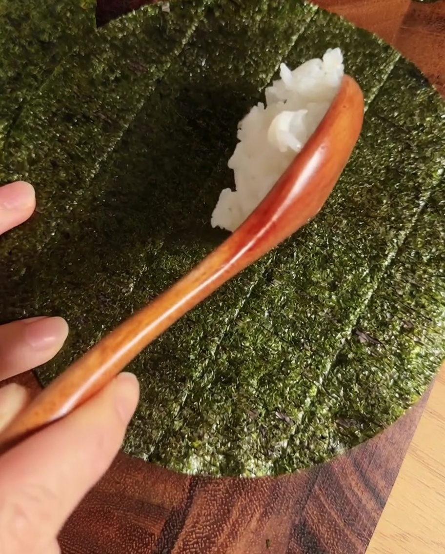 円形の海苔の中央に酢飯を一本の線状に置いた状態。