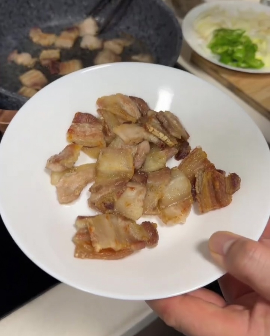 フライパンで豚バラ肉がこんがりと焼き色がついている様子。