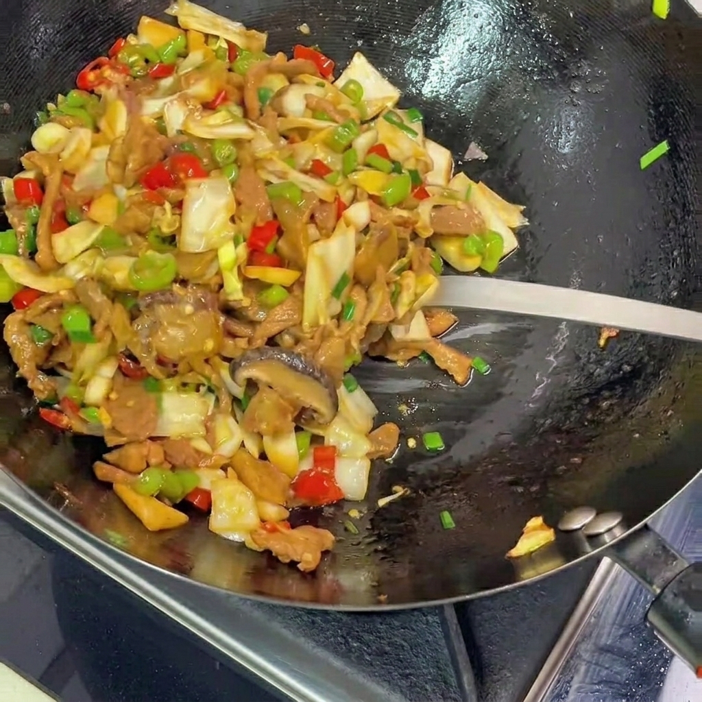 炒めあがった料理を皿に盛り付ける様子。