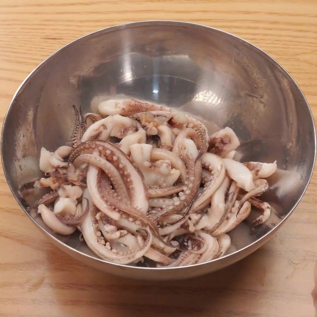 新鮮なイカの足を沸騰したお湯にサッとくぐらせている様子。