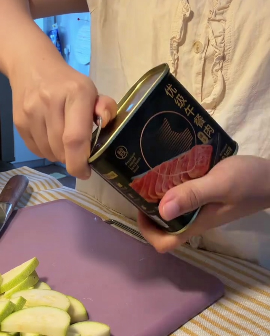開けた缶からランチミートの塊を取り出している様子。