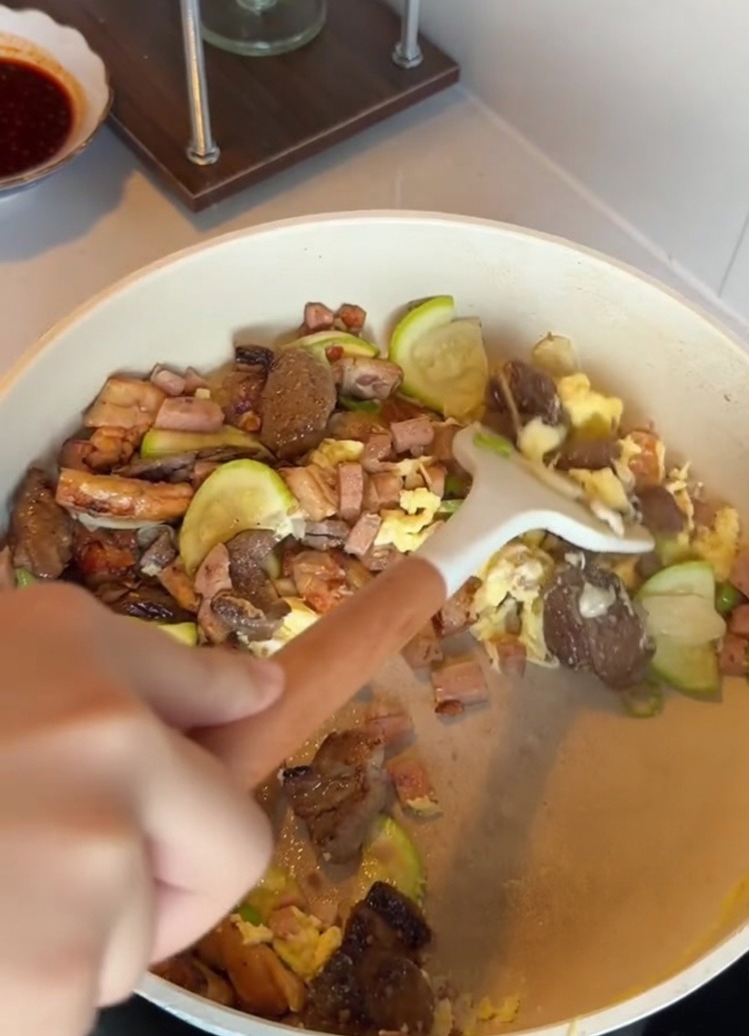 具材の入ったフライパンに、炊きたてのご飯を加えている様子。