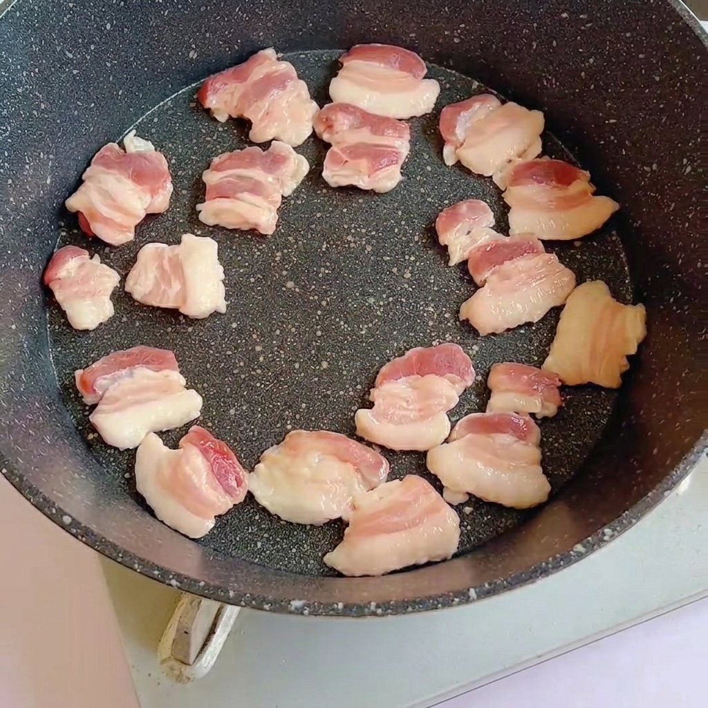 フライパンで豚バラ肉を炒めている様子。