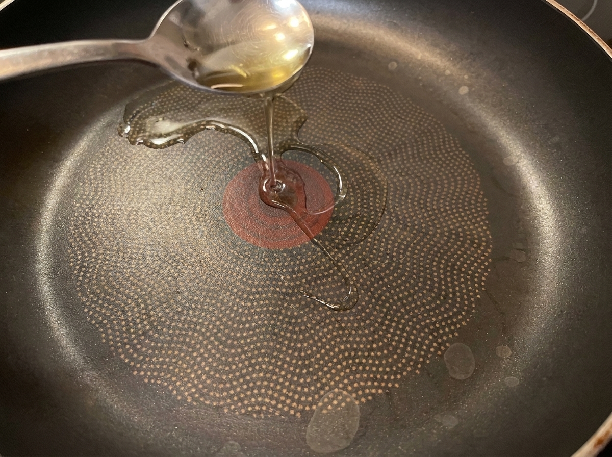 熱したフライパンに、刻んだネギと味付けしたキムチを加えている様子。