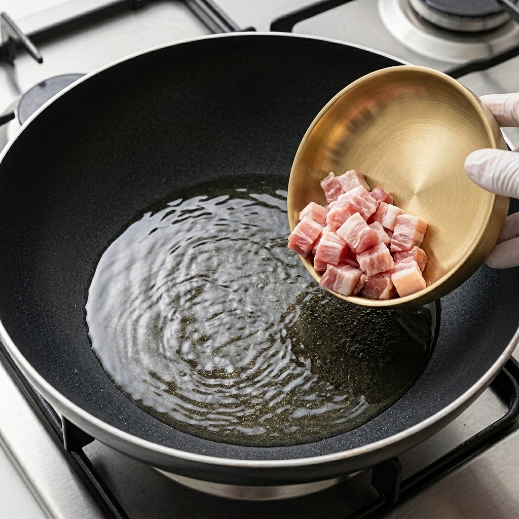 熱したフライパンで豚バラ肉を焼いている様子