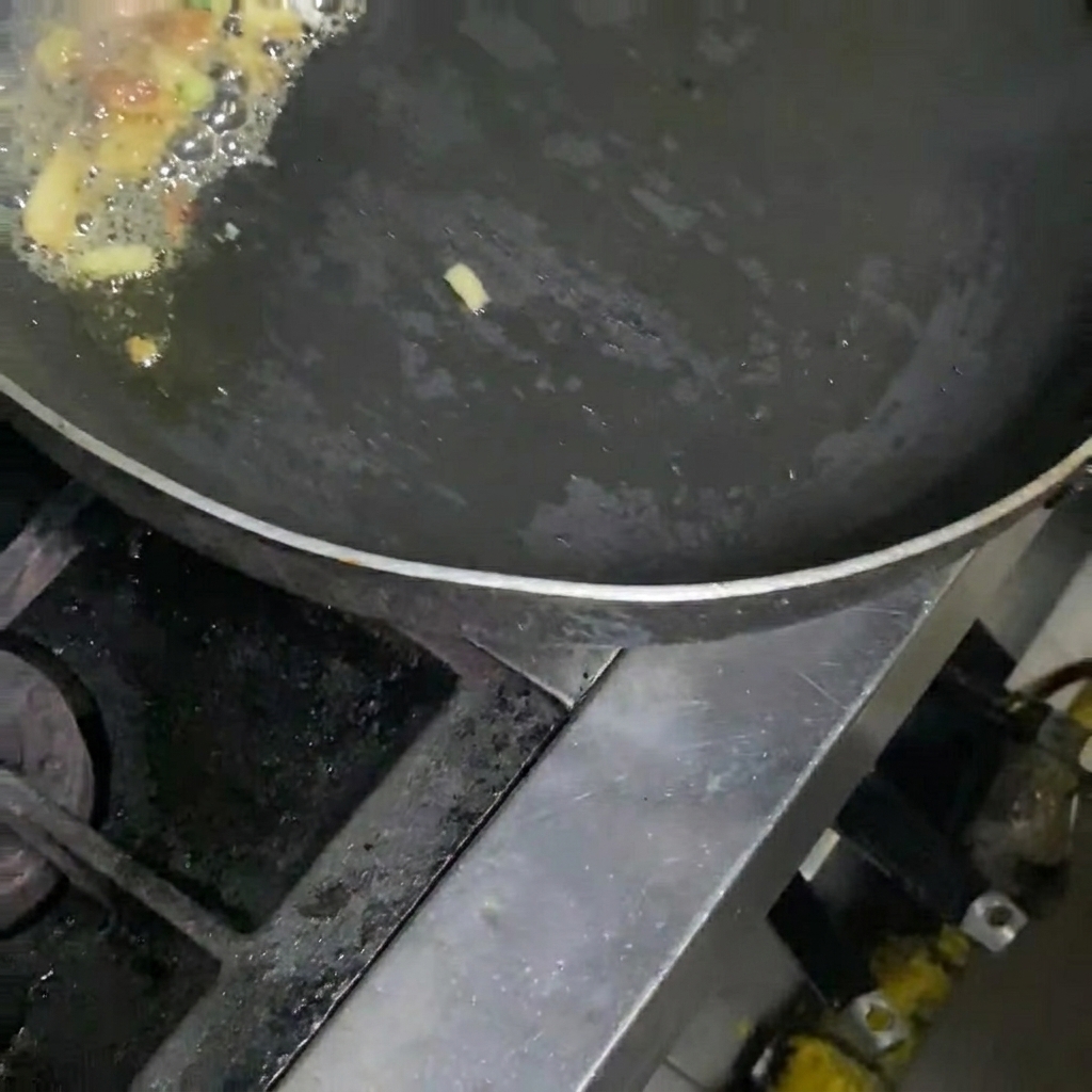 フライパンでキムチ、豚肉、ネギを炒めている様子