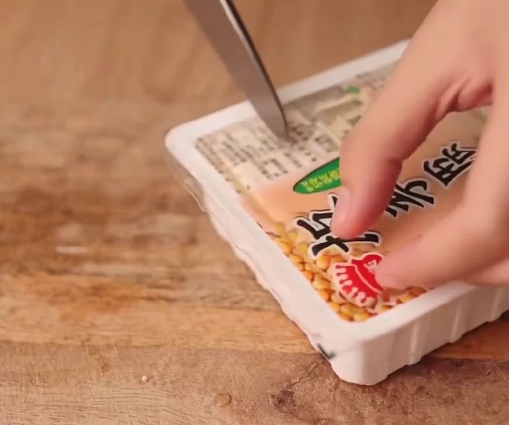 まな板の上で木綿豆腐を均等な厚さに切る様子。