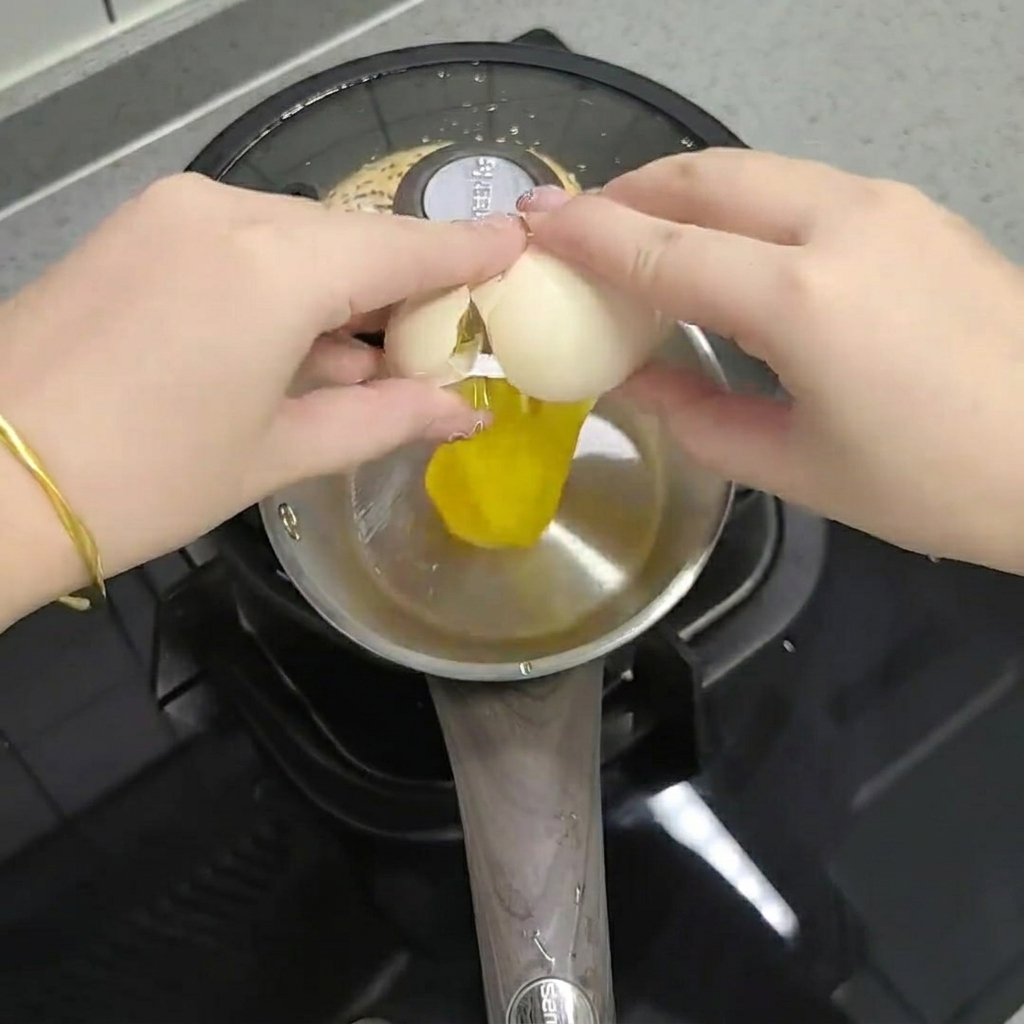 小さな容器でチリオイル、スパイス、ネギと卵を混ぜ合わせる様子