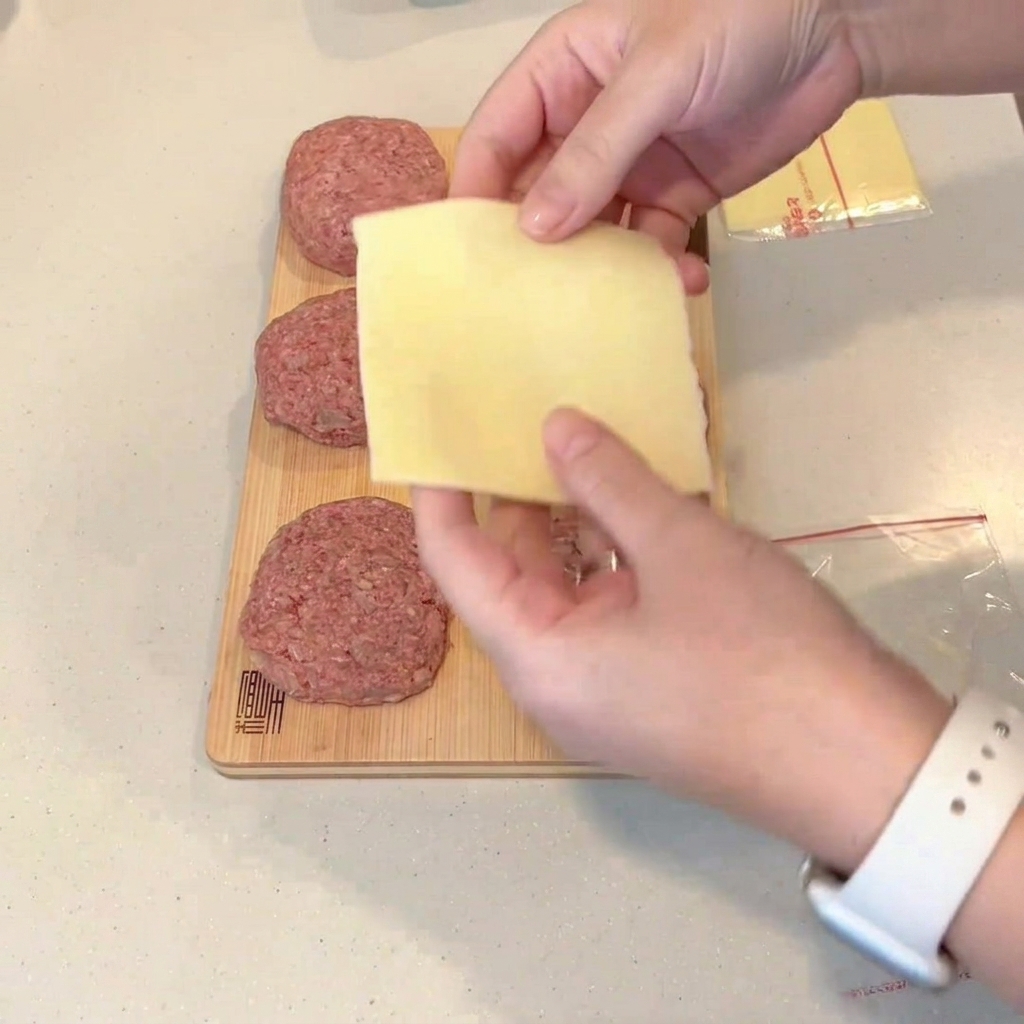 平らにした肉の中央に折りたたんだチーズを乗せる様子。