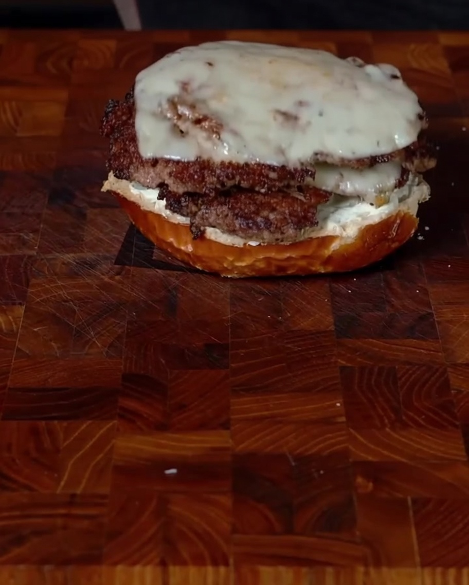 クリームチーズを塗った下のバンズに、チーズが溶けたハラペーニョパティを2枚重ねてのせている様子