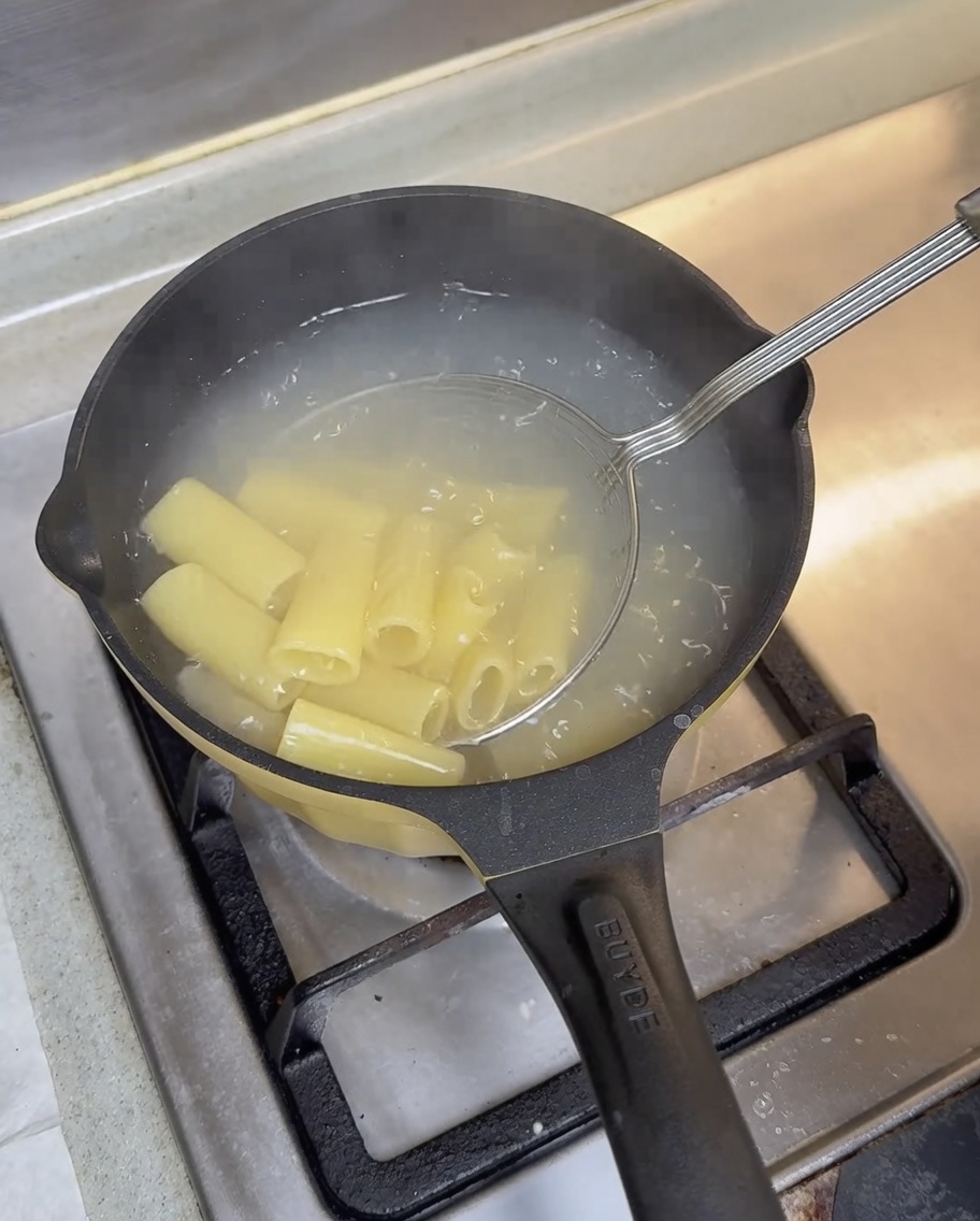 茹で上がったパスタをザルですくい上げている様子。