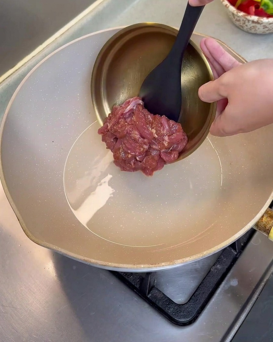 熱したフライパンで豚肉を炒めている様子。