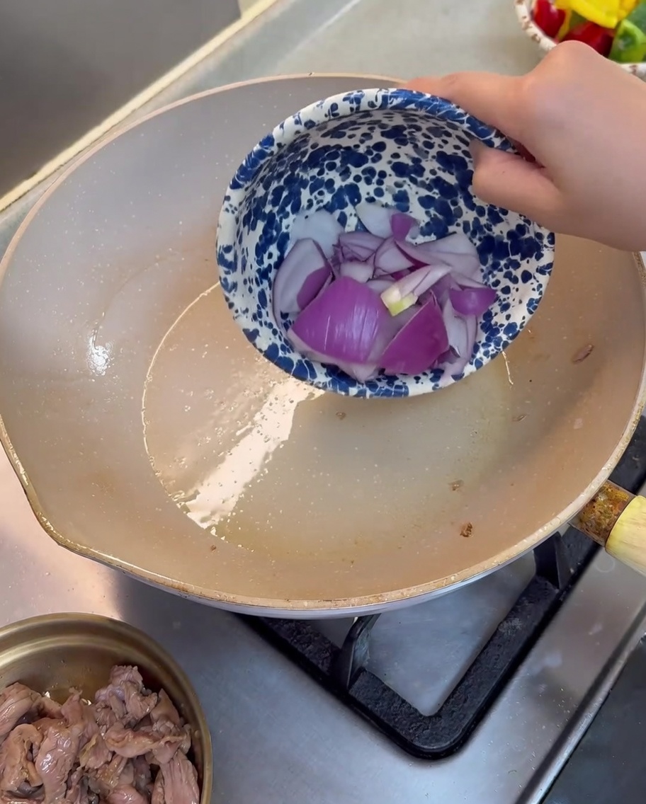 フライパンで紫玉ねぎを炒めている様子。