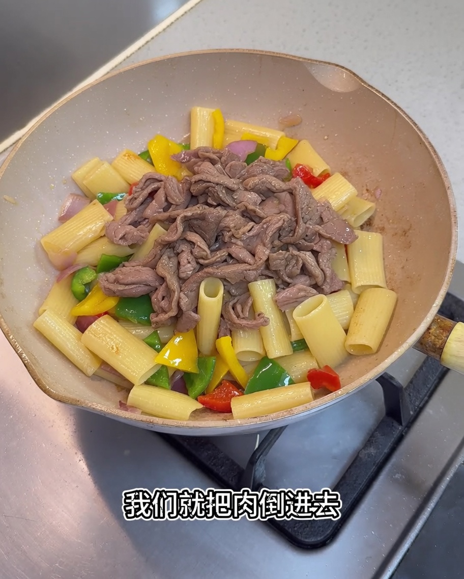肉をフライパンに戻し、ソースを回しかけている様子。