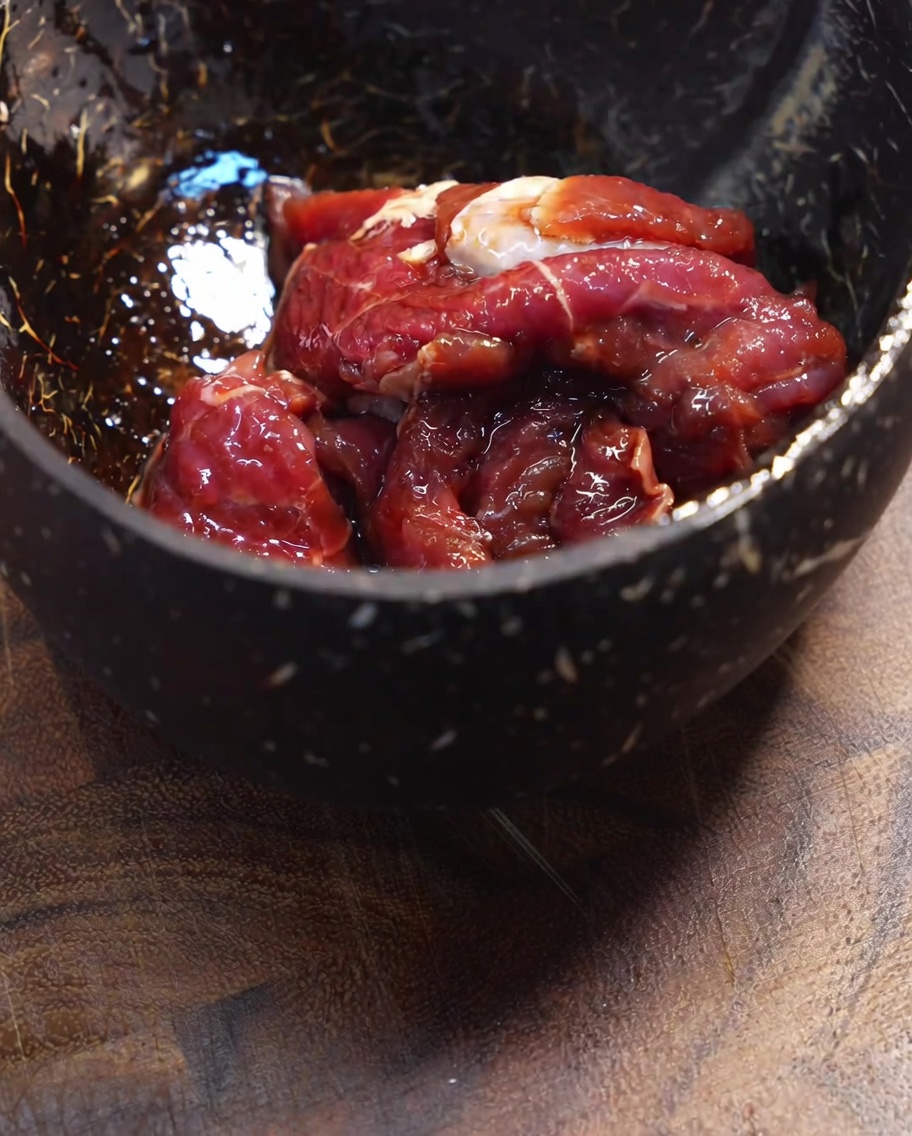 牛肉に片栗粉を加えて混ぜている様子。