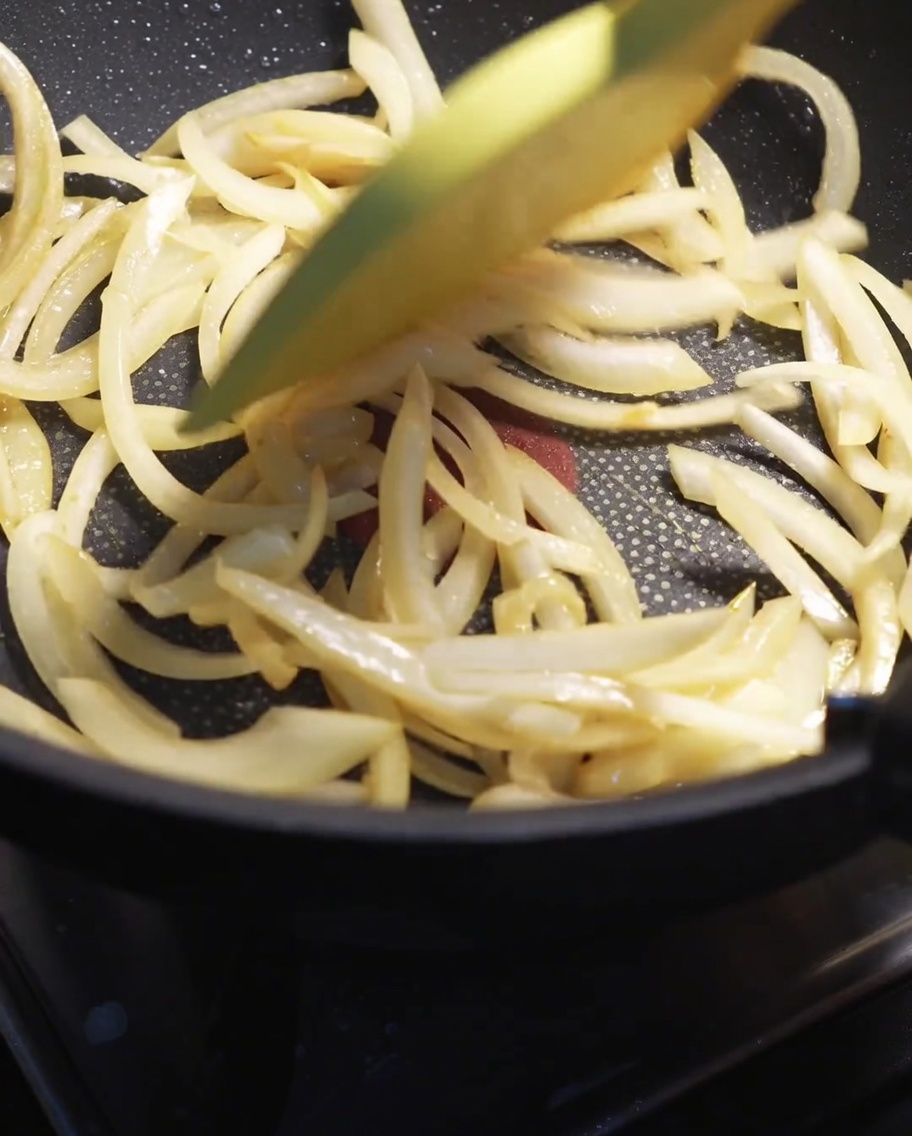 玉ねぎを炒めてしんなりさせている様子。