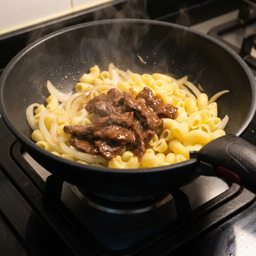 フライパンに牛肉を戻し入れている様子。