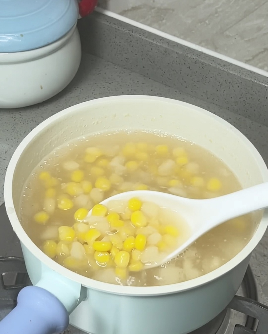 完成したコーンとクワイのスープにココナッツミルクを回しかけている様子。