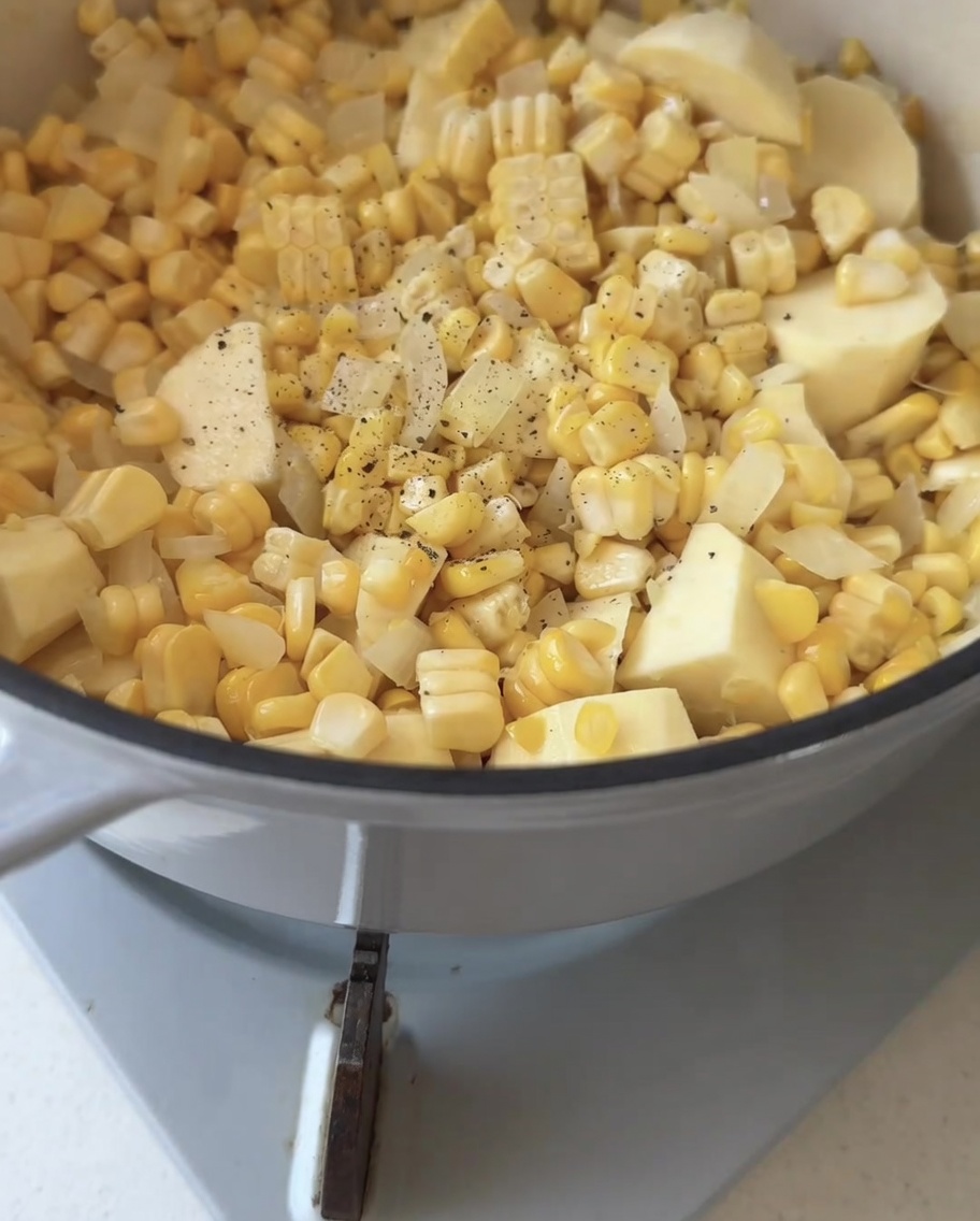 鍋に入った野菜の上に、黒こしょうを挽き入れている様子。