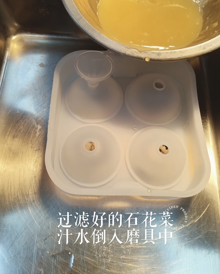 小さな漏斗を使って、黄金色の寒天液をシリコン型に注ぎ入れている様子。