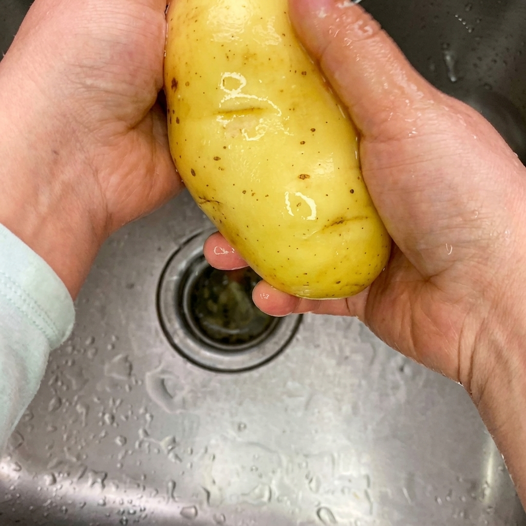 まな板の上に置かれた細切り状の生のじゃがいも。