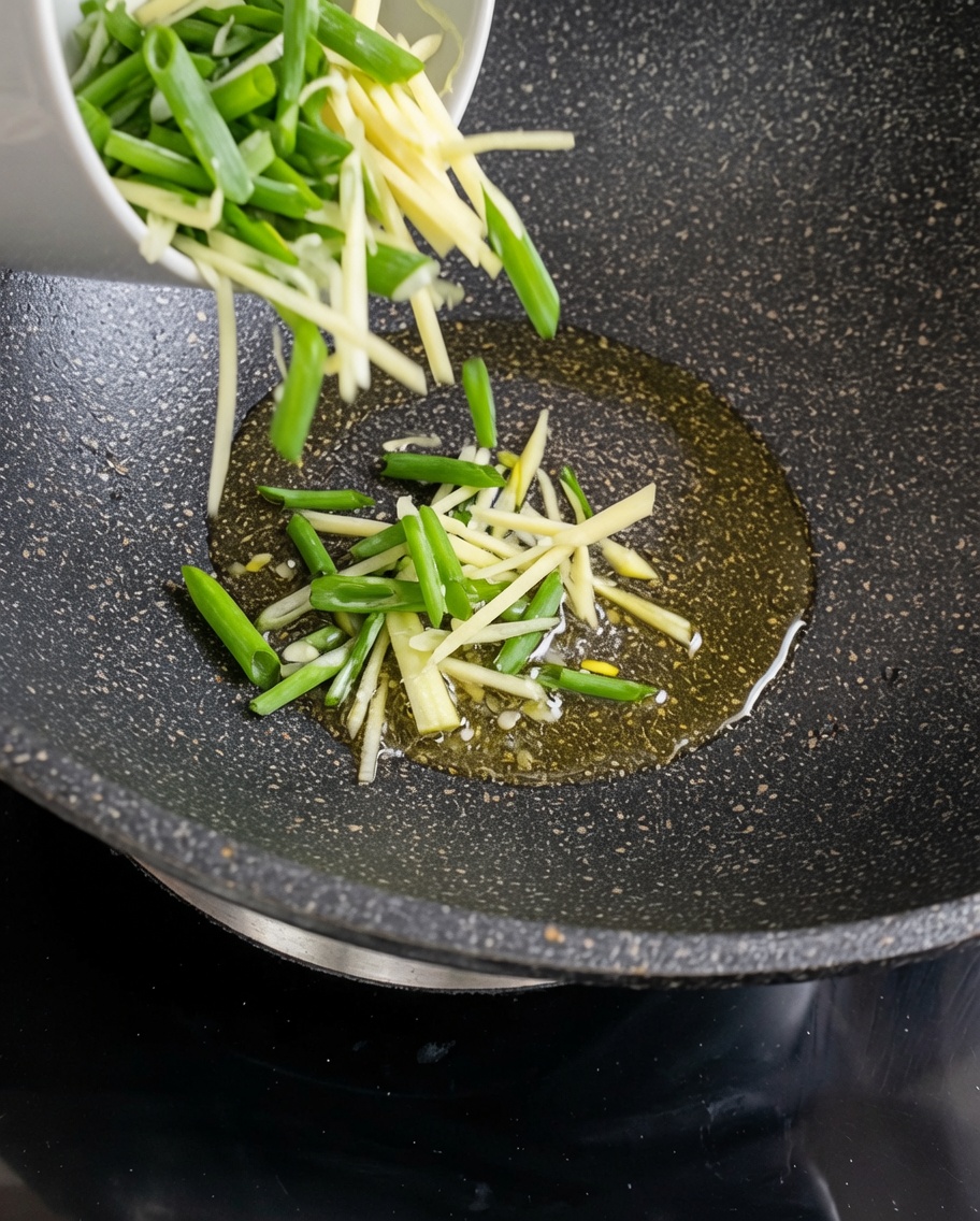 熱した油の中華鍋で炒められている細切りじゃがいも。