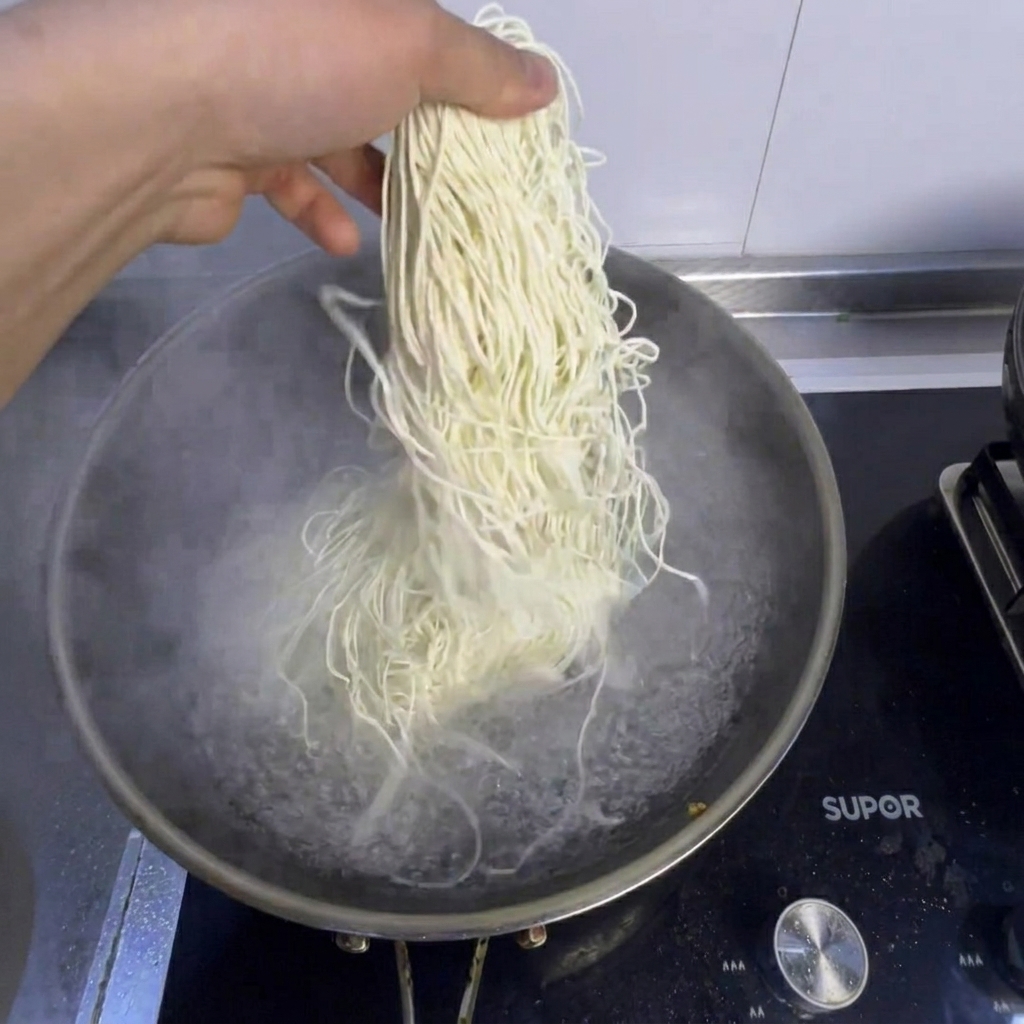 別の鍋で麺と青梗菜を茹でている様子。